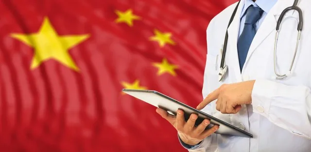 Médico consultando una tableta delante de una bandera china